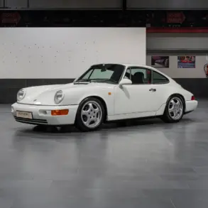 Weißer Porsche 964 RS steht in einer Hallengarage, Fahrerseite sichtbar