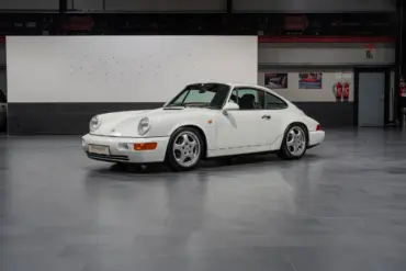 Weißer Porsche 964 RS steht in einer Hallengarage, Fahrerseite sichtbar