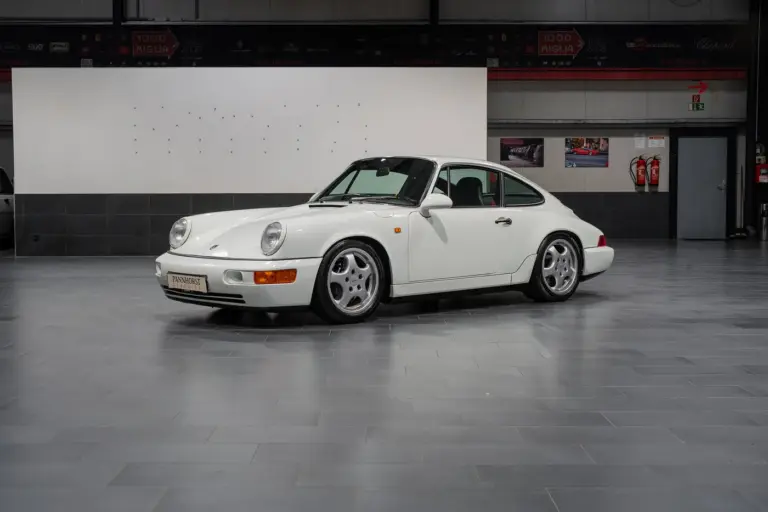 Weißer Porsche 964 RS steht in einer Hallengarage, Fahrerseite sichtbar