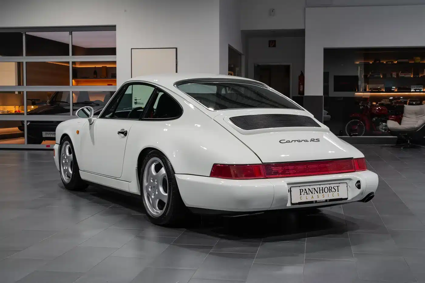 Weißer Porsche 964 Carrera RS Heckansicht im Showroom von Pannhorst Classics