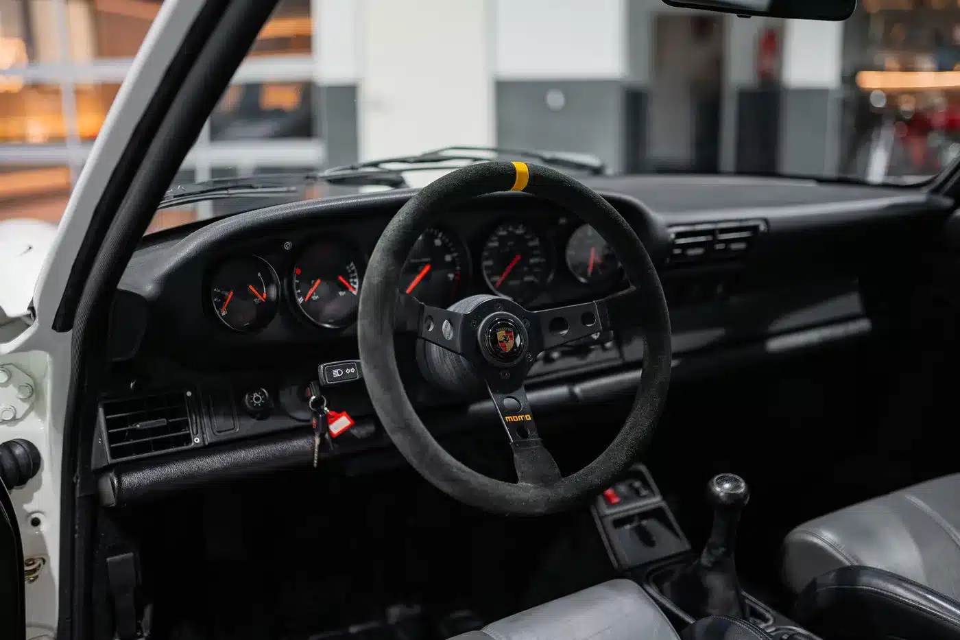 Blick auf das Cockpit eines Porsche 964 RS mit Momo-Lenkrad und klassischen Rundinstrumenten