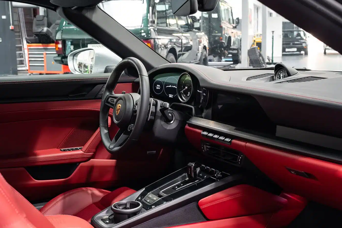 Innenraumansicht des Porsche 992 911 Carrera GTS Cabriolet mit rotem Leder und Sportlenkrad