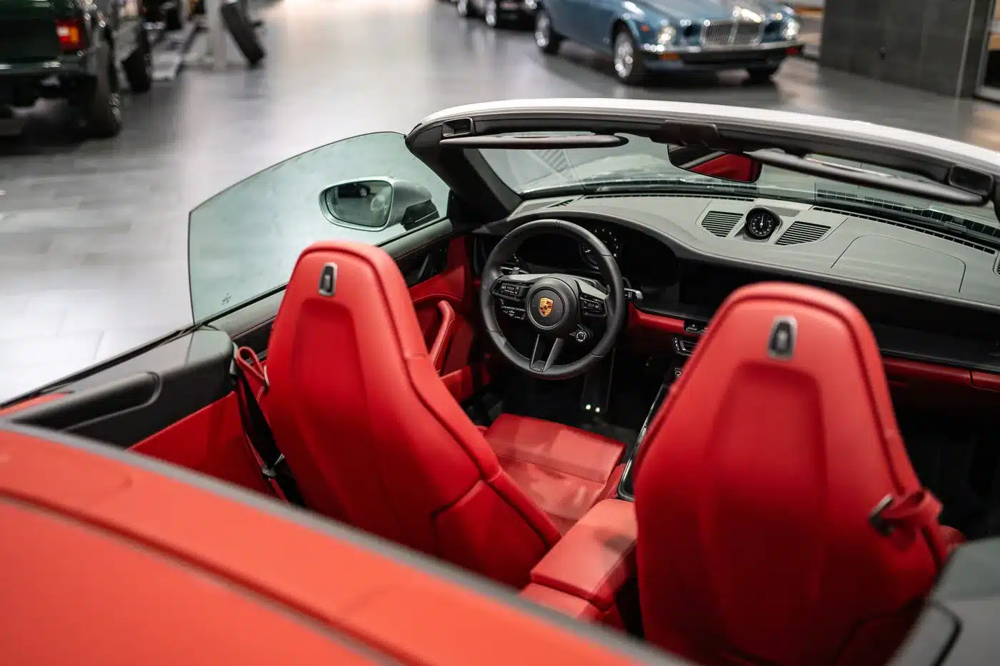 Blick ins Cockpit und auf die Vordersitze eines Porsche 992 911 Carrera GTS Cabriolet mit rotem Lederinterieur