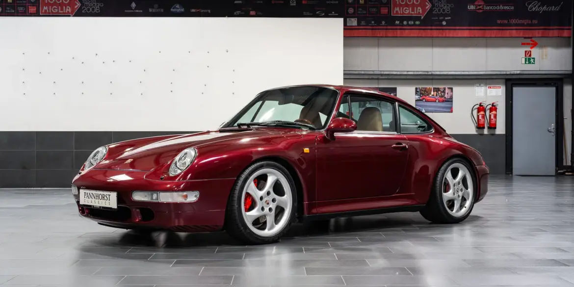 Porsche 993 Carrera 4S in Arena Red Metallic, fotografiert in einer Halle, Beigefarbenes Lederinterieur sichtbar
