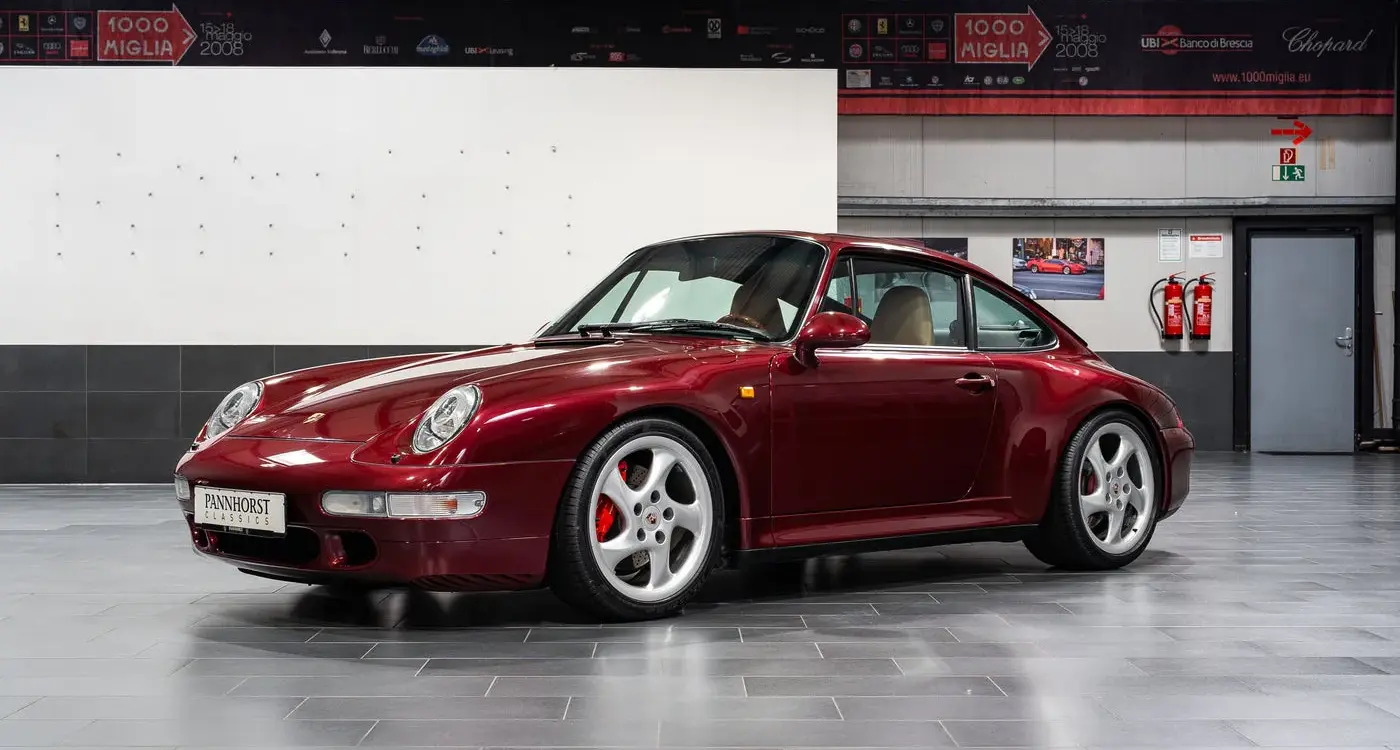 Porsche 993 Carrera 4S in Arena Red Metallic, fotografiert in einer Halle, Beigefarbenes Lederinterieur sichtbar