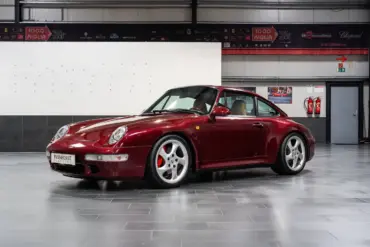 Porsche 993 Carrera 4S in Arena Red Metallic, fotografiert in einer Halle, Beigefarbenes Lederinterieur sichtbar