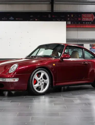 Porsche 993 Carrera 4S in Arena Red Metallic, fotografiert in einer Halle, Beigefarbenes Lederinterieur sichtbar