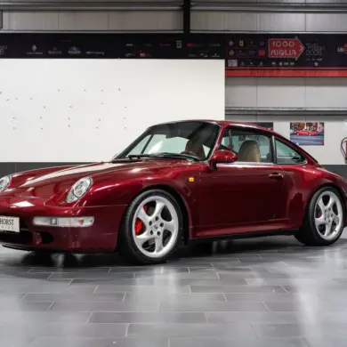 Porsche 993 Carrera 4S in Arena Red Metallic, fotografiert in einer Halle, Beigefarbenes Lederinterieur sichtbar