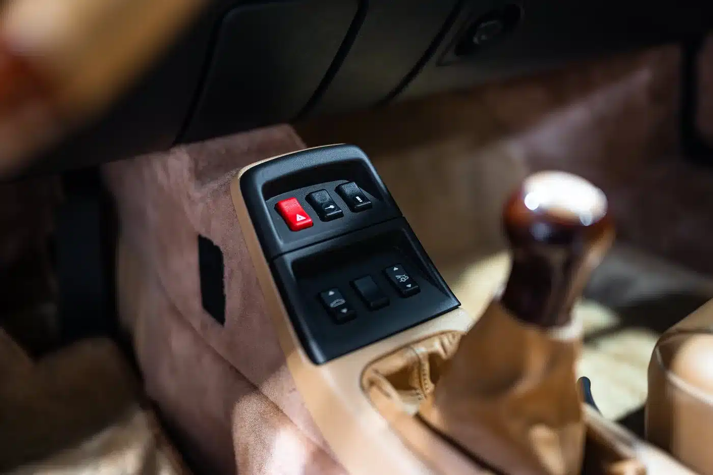 Mittelkonsole mit Schaltern und Schalthebel im beigefarbenen Interieur eines Porsche 993 Carrera 4S
