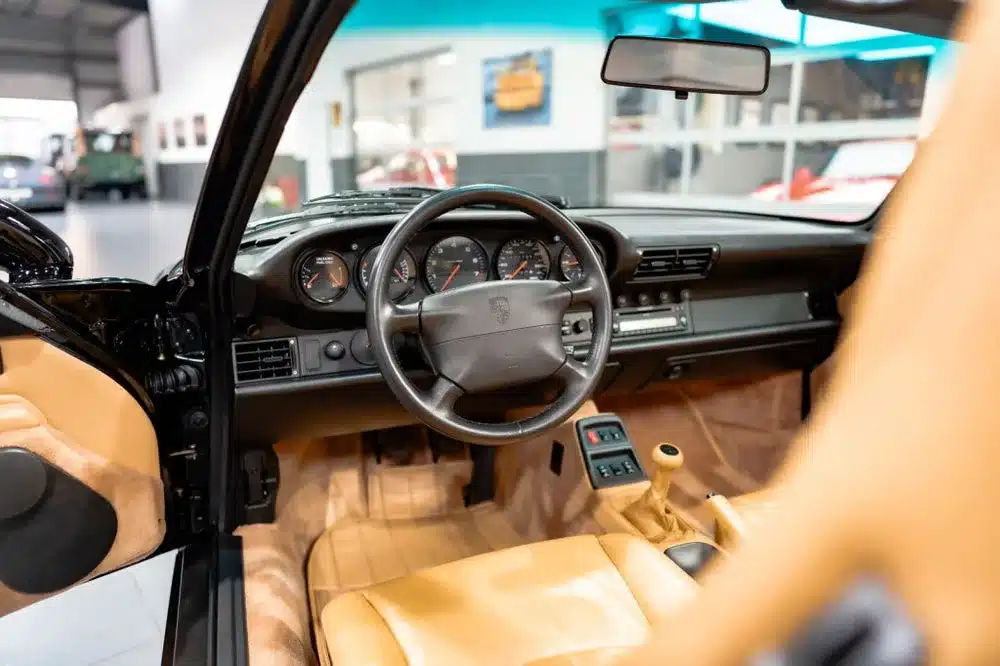 Innenraum eines Porsche 993 Carrera Cabriolet mit beigem Leder und Handschaltung