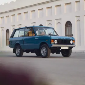 Restaurierter Range Rover Classic in Tuscan Blue, Baujahr 1975, steht auf einer Straße vor einem hellen Gebäude mit Rundbogenfenstern