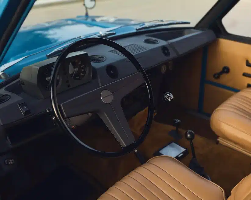 Innenansicht eines Range Rover Classic von 1975 in Tuscan Blue mit beige bezogenen Sitzen und Originalarmaturen.