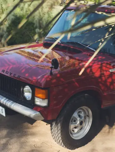 Range Rover Classic 1976, zweitäurig, Masai Red, restauriert, im Sonnenschatten geparkt, Vorderansicht