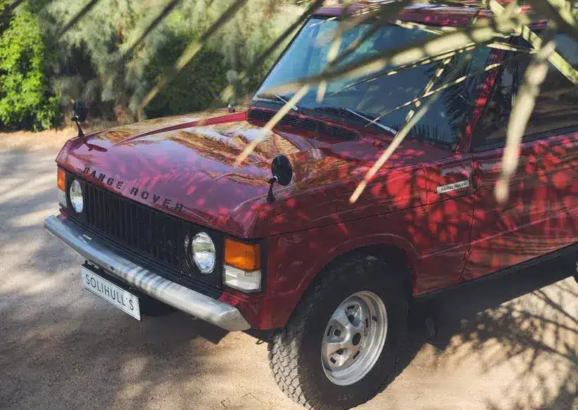 Range Rover Classic 1976, zweitäurig, Masai Red, restauriert, im Sonnenschatten geparkt, Vorderansicht