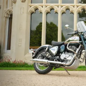 Royal Enfield Classic 350 Motorrad, Chrom und Blau, geparkt vor einem Gebäude mit gotischen Fenstern