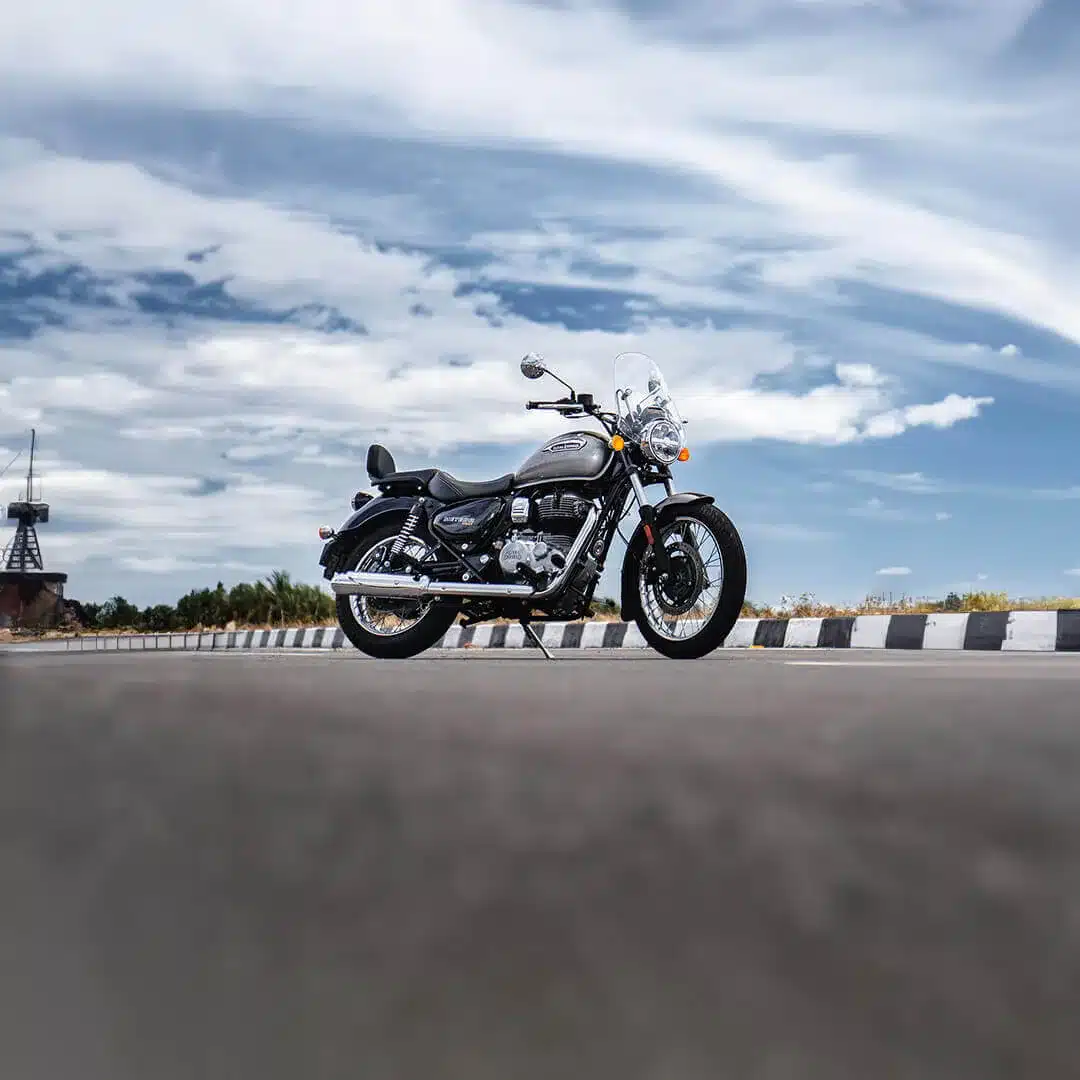 Royal Enfield Meteor 350 Motorrad auf einer leeren Straße bei Tag vor bewölktem Himmel.