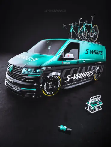 VW Transporter mit Specialized S-Works-Folierung, blauen und schwarzen Akzenten, RAYS TE37 Felgen und zwei Rennrädern auf dem Dachträger.