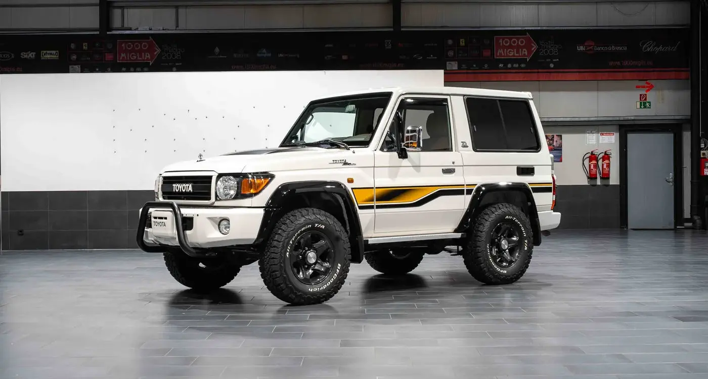 Weißer Toyota Land Cruiser 70 Jahre Edition mit klassischen Geländewagen-Details in einer Halle.