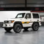 Weißer Toyota Land Cruiser 70 Jahre Edition mit klassischen Geländewagen-Details in einer Halle.