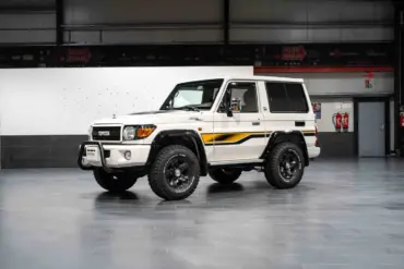 Weißer Toyota Land Cruiser 70 Jahre Edition mit klassischen Geländewagen-Details in einer Halle.