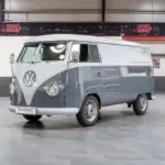 Grau lackierter Volkswagen VW T1 Kastenwagen Baujahr 1956 in einer Halle, frontal schräg fotografiert.