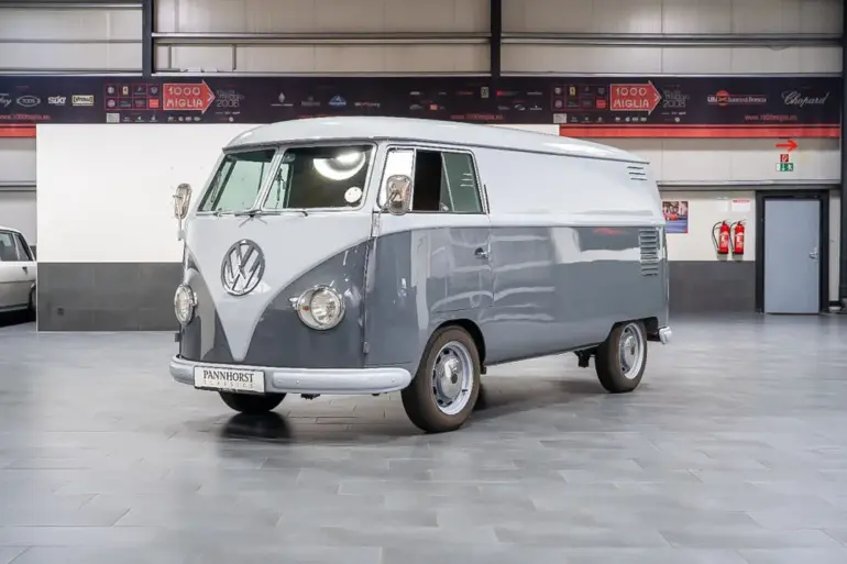 Grau lackierter Volkswagen VW T1 Kastenwagen Baujahr 1956 in einer Halle, frontal schräg fotografiert.