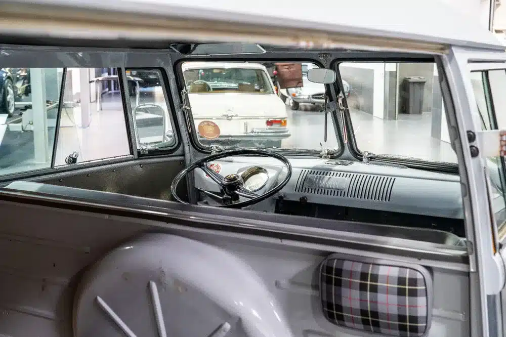 Innenraum und Armaturenbrett eines grauen VW T1 Kastenwagens mit geöffneten Safari-Frontscheiben, Baujahr 1956