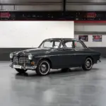 Restauriertes Volvo Amazon Coupé, Baujahr 1964, in dunkler Farbe, Seitenansicht in einer modernen Halle.