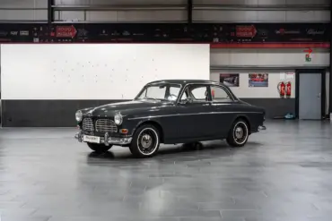 Restauriertes Volvo Amazon Coupé, Baujahr 1964, in dunkler Farbe, Seitenansicht in einer modernen Halle.