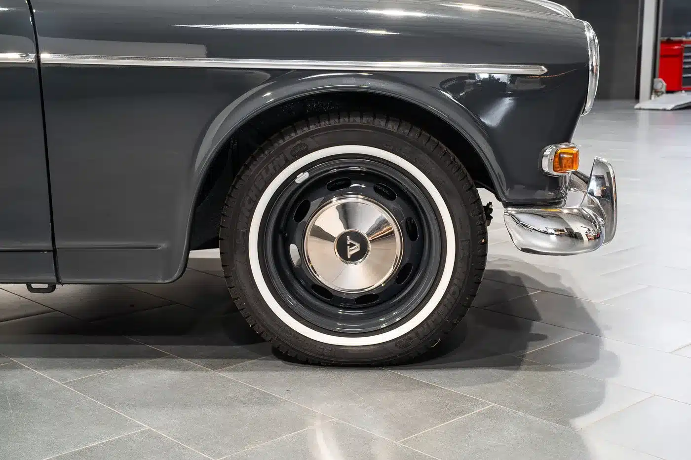 Nahaufnahme des Vorderrads mit Chromstoßstange und klassischer Felge eines Volvo Amazon Coupé von 1964