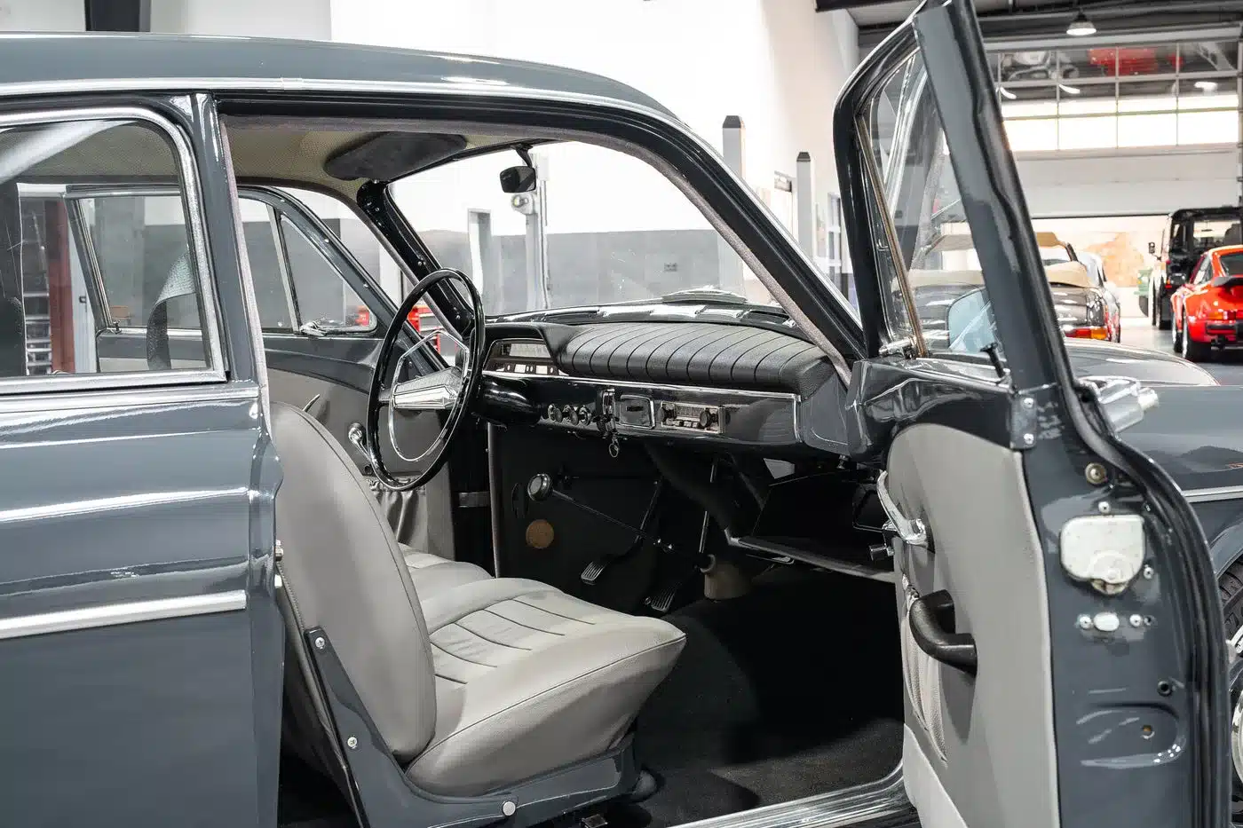 Restaurierter Innenraum eines Volvo Amazon Coupé, Baujahr 1964, mit geöffneten Türen und gepflegten Sitzen.