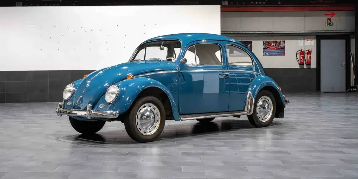 Blauer VW Käfer 1200 aus dem Jahr 1964 im originalen Zustand in einer Ausstellungshalle.