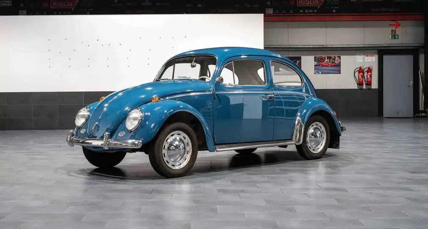 Blauer VW Käfer 1200 aus dem Jahr 1964 im originalen Zustand in einer Ausstellungshalle.