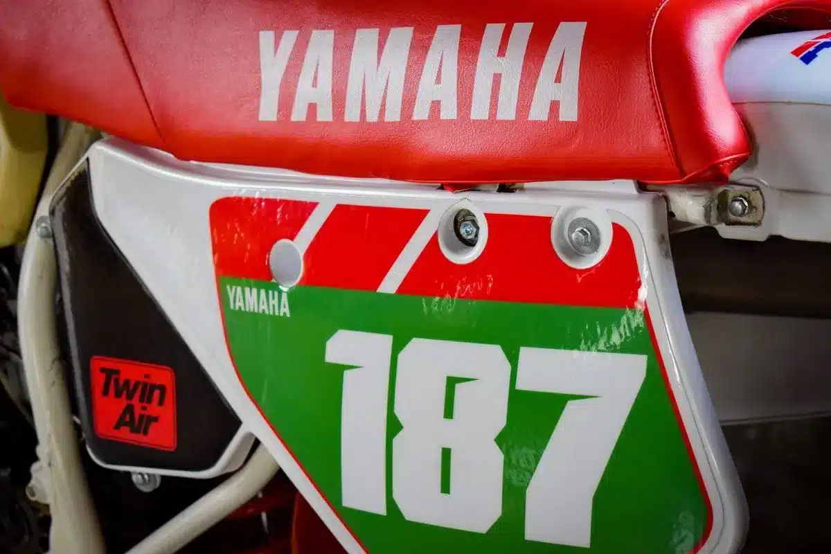 Detailaufnahme des Seitenteils und der roten Sitzbank einer Yamaha YZ250 von 1987 mit Chesterfield-Design.