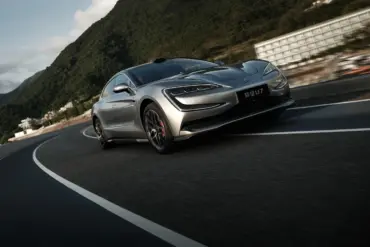 Silberner YangWang U7 fährt auf einer kurvigen Bergstraße, im Vordergrund die markante Front des Flaggschiffs, umgeben von grüner Hügellandschaft.