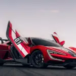 Yangwang U9 Xtreme mit geöffneten Flügeltüren auf einer Rennstrecke, seitliche Ansicht.