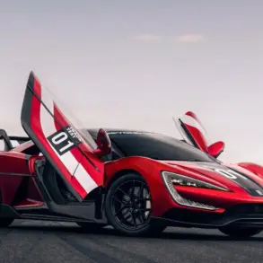 Yangwang U9 Xtreme mit geöffneten Flügeltüren auf einer Rennstrecke, seitliche Ansicht.