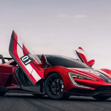 Yangwang U9 Xtreme mit geöffneten Flügeltüren auf einer Rennstrecke, seitliche Ansicht.