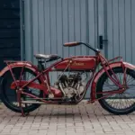 1925 Indian Scout Motorrad, restauriert, im originalen roten Lack, vor Garagentor fotografiert.
