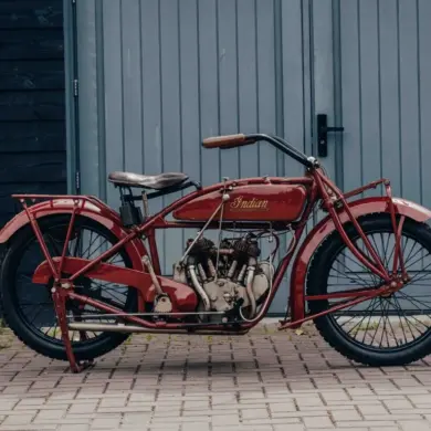 1925 Indian Scout Motorrad, restauriert, im originalen roten Lack, vor Garagentor fotografiert.
