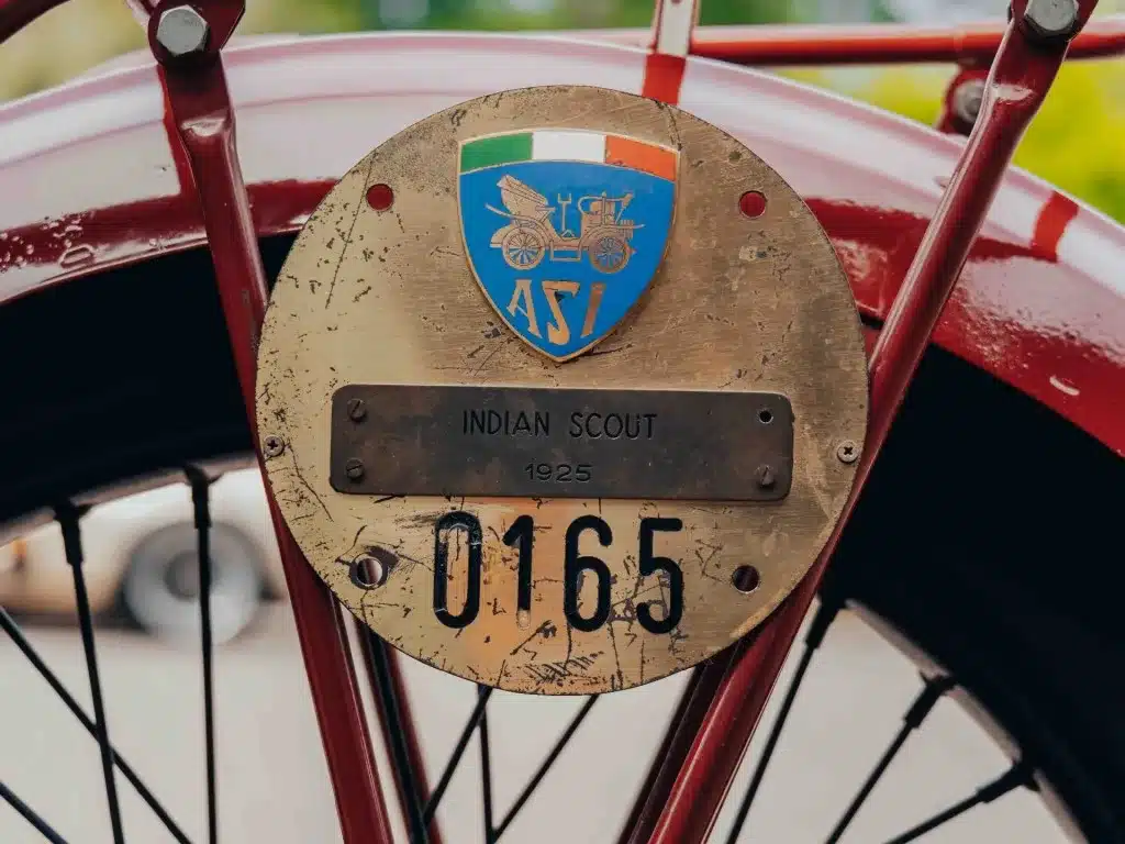 Messingschild mit Emblem und der Aufschrift 'Indian Scout 1925' an einem roten Schutzblech