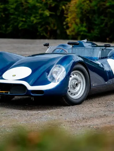 Lister-Jaguar Knobbly Continuation in Blau auf Schotter, Rennsport-Silhouette von vorn schräg fotografiert.