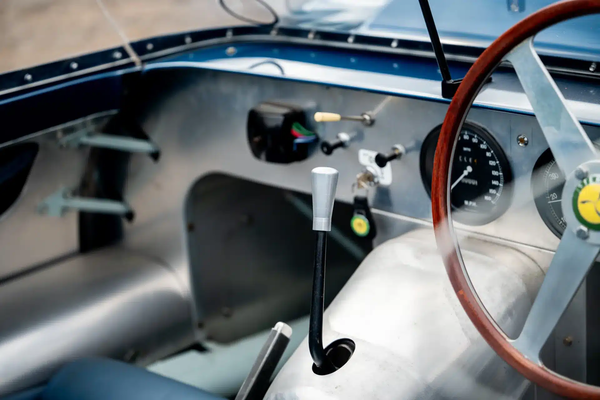 Innenraum des Lister-Jaguar Knobbly mit Aluminiumarmaturenbrett, Holzlenkrad und Schalthebel.