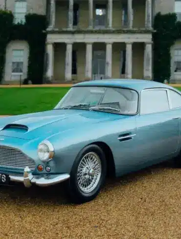 Aston Martin DB4 Series III Vantage 1961 in Caribbean Pearl, geparkt vor einem Herrensitz.