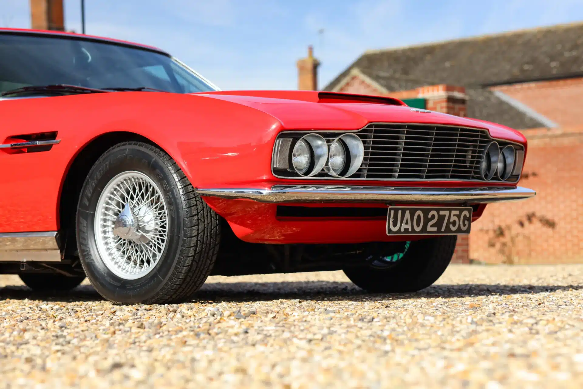 Die Frontpartie eines roten Aston Martin DBS von 1969 mit klassischem Grill und Doppelscheinwerfern
