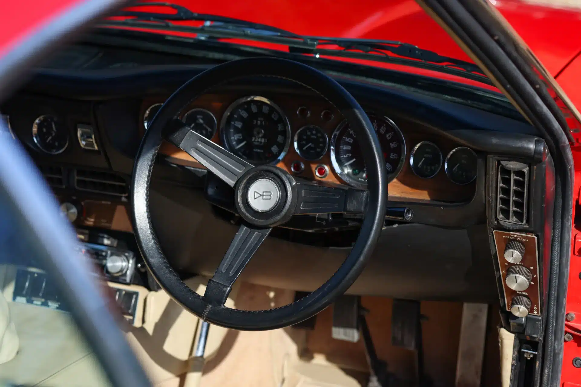 Lenkrad, Armaturen und beiges Leder im Cockpit eines Aston Martin DBS von 1969
