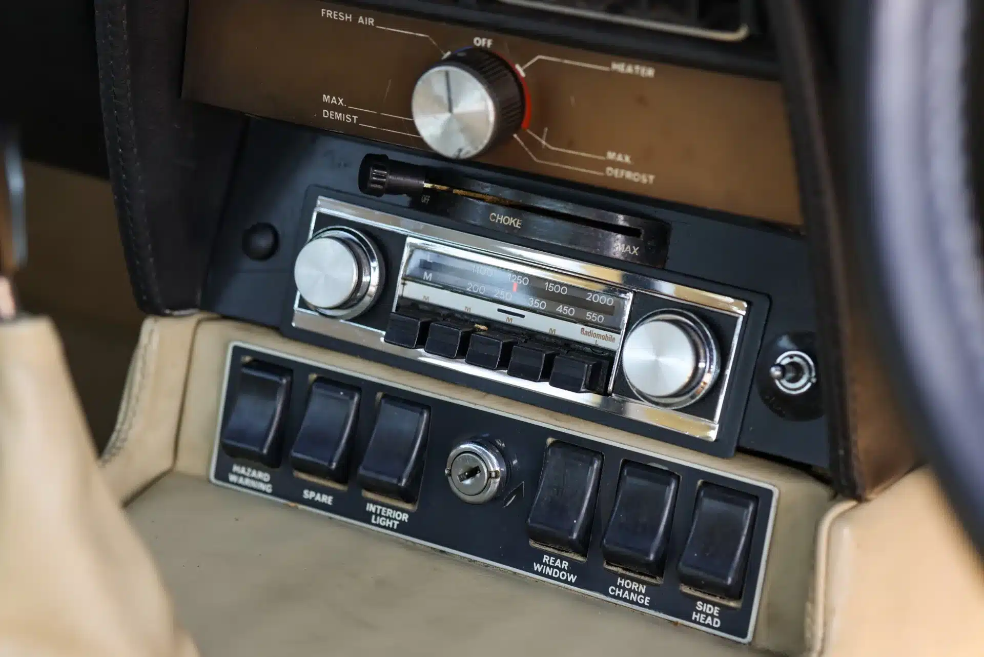 Nahaufnahme Radio und Schalterkonsole im 1969 Aston Martin DBS mit beigem Lederinterieur.