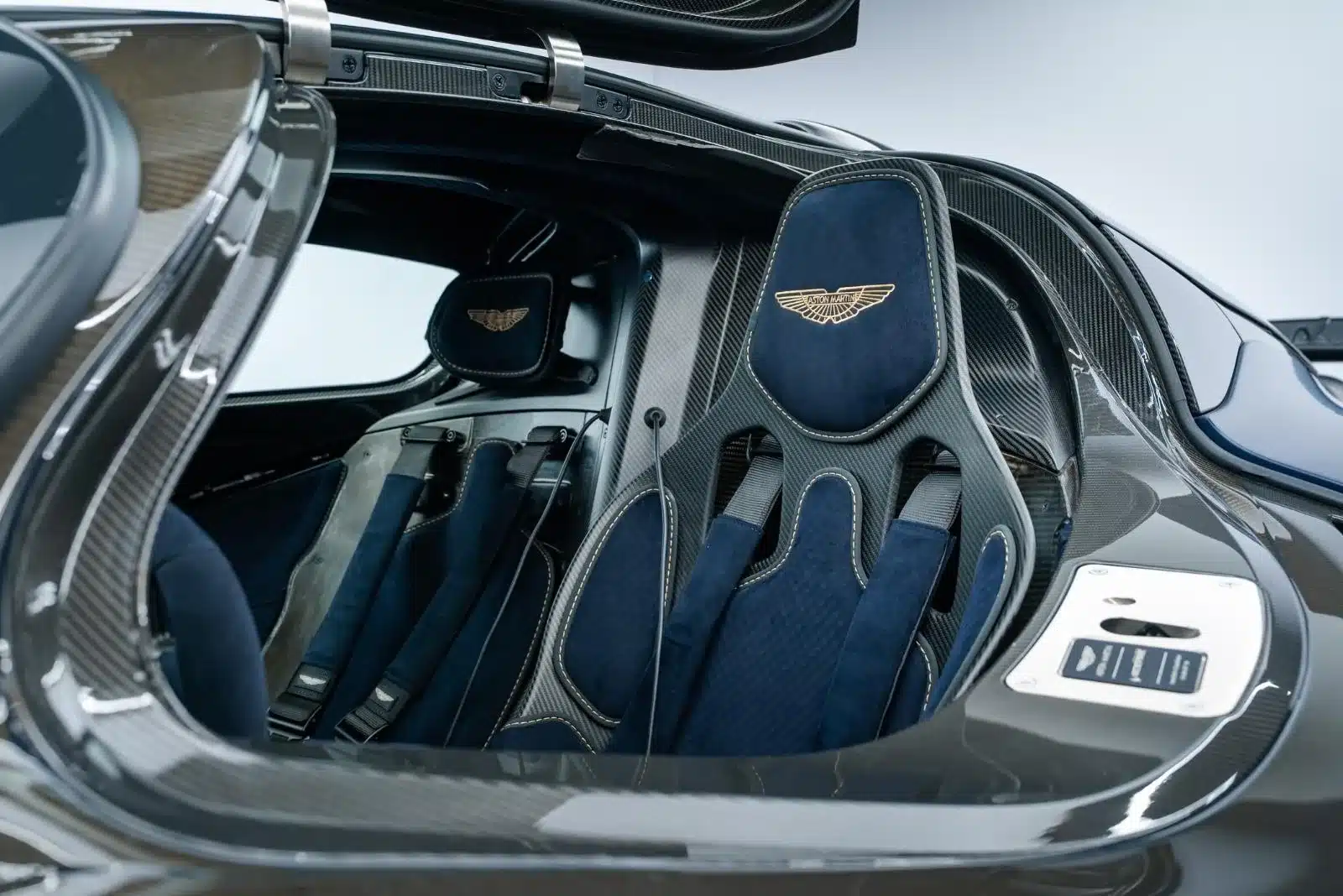 Cockpit und Schalensitz eines Aston Martin Valkyrie mit sichtbarer Karbonstruktur und goldener Stickerei.