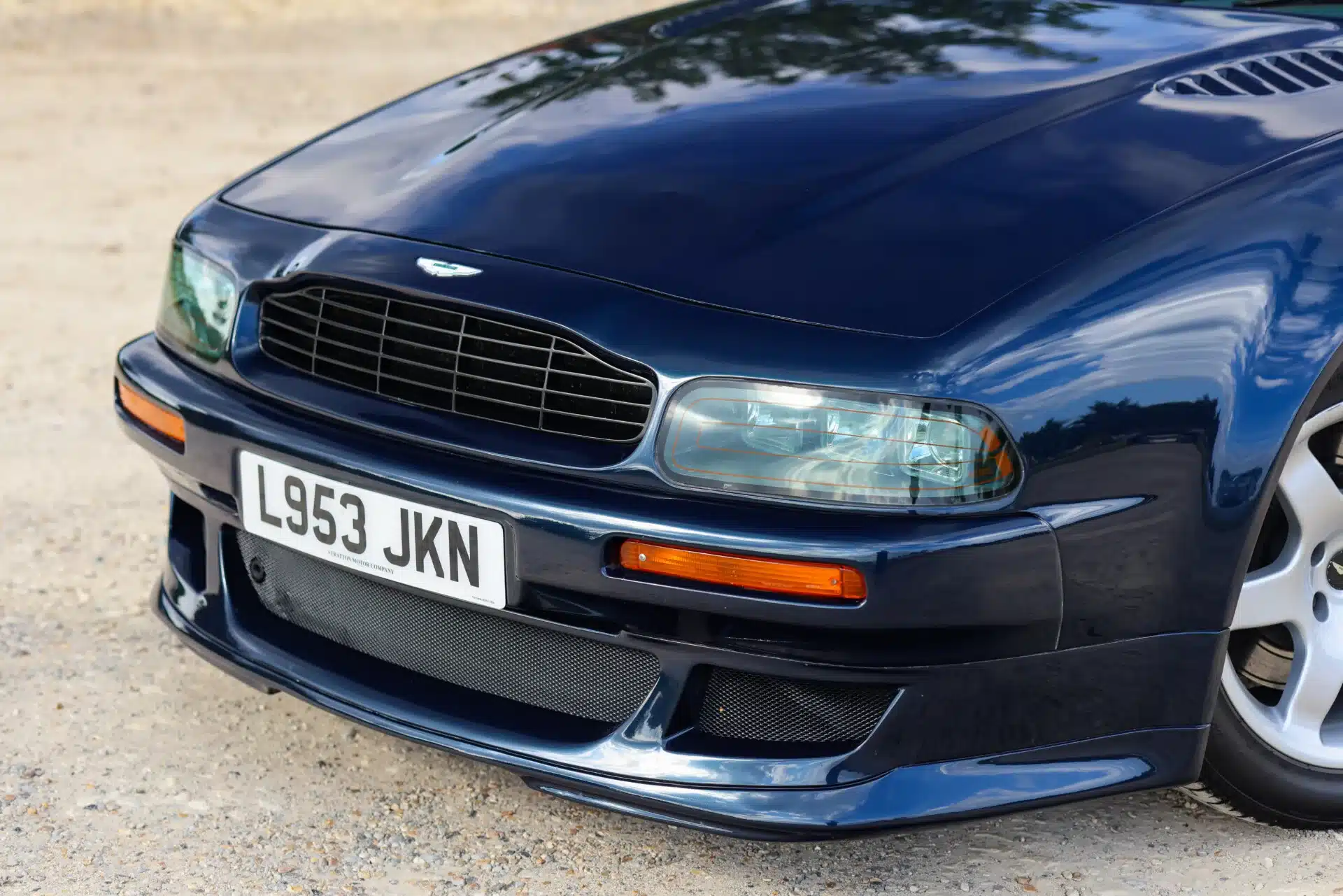 Aston Martin Vantage V550 in dunkelblau, Ausschnitt der Front mit Kühlergrill, Scheinwerfern und Nummernschild L953 JKN
