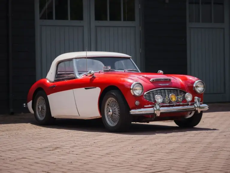 Austin-Healey 3000 MK1 BT7, Baujahr 1959, mit roter Lackierung und weißem Werks-Hardtop, von schräg vorne fotografiert.